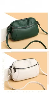 Detail view of stylish crossbody bags in dark green and cream with lychee grain leather