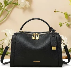 Détail du sac à main en cuir noir grainé avec fermetures dorées et logo de mode chic