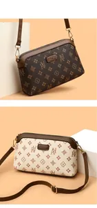 Detail view of vintage patterned crossbody bags in brown and beige with gold zippers
