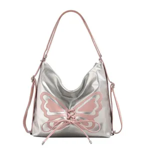 Silver metallic butterfly shoulder bag with pink lace-up details and adjustable strap