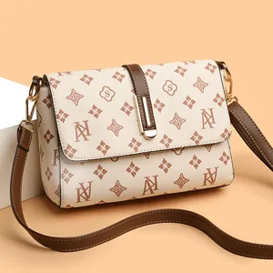 Chique beige crossbodytas met vintage monogram en gouden metalen accessoires