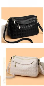 Close-up of dual-color quilted faux leather handbags with three zip compartments