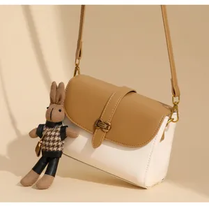 Detailansicht der Khaki-Beige Umhängetasche mit Hasenanhänger und Bronzeschnalle