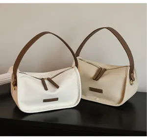 Detailed view of the lychee grain leather texture and stitching on these minimalist handbags