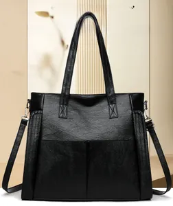 Detail of black pebbled leather tote with silver hardware and detachable strap
