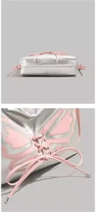 Detail of silver metallic bag with pink butterfly wings and decorative lacing accents