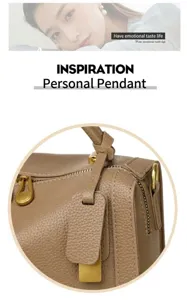 Détail d'un sac cabas en cuir grainé marron avec finitions dorées et pendentif