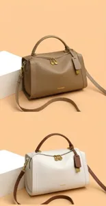 Détail de sacs Boston en cuir grainé avec double fermeture éclair et accessoires dorés