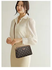 Detailed view of women's crossbody phone bag with brown vintage pattern and slim leather strap