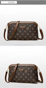 Close-up of vintage brown leather crossbody bag with logo and gold hardware details