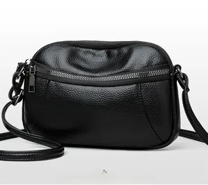 Detail view of the black lychee pattern leather shoulder bag with dual zippers and gunmetal hardware
