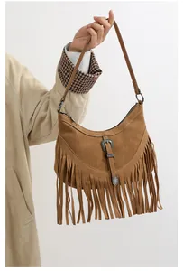 Détail du sac hobo en daim vintage avec boucle occidentale et franges élégantes