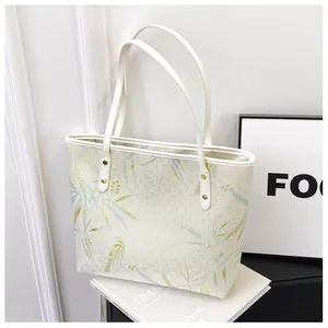 Elegant Chinoiserie tote bag with blue bird and bamboo leaf patterns on beige fabric