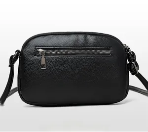 Detail view of the black leather crossbody bag featuring a secure back zipper pocket