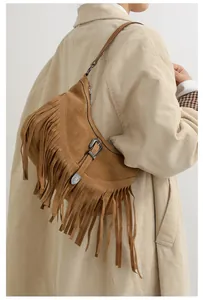 Détail d'un sac bandoulière en daim marron avec de longues franges et boucle en métal vintage