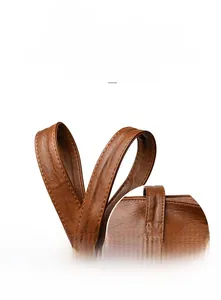 Detail of reinforced handles and stitching on brown leather tote bag with lychee texture