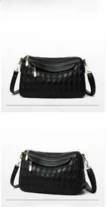 Detail view of black quilted crossbody bag with multi-zipper layers and gold hardware