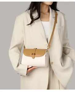 Detail der eleganten Umhängetasche in Beige und Karamell mit Hufeisen-Metallschnalle