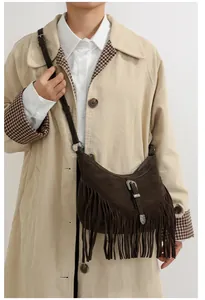 Détail du sac bandoulière en daim marron foncé avec franges et boucle en métal rétro
