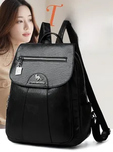 Detail of black faux leather backpack with kangaroo metal logo and front zipper pocket
