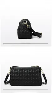 Detail of black crossbody bag with quilted rhombic pattern and gold-tone hardware