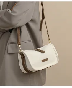 Close-up of beige leather bucket bag with brown strap and fine pebbled texture
