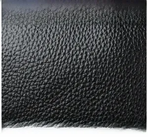 Macro shot showing high-quality black litchi pattern leather texture of the bag