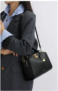 Nahaufnahme der schwarzen Lychee-Maserung und goldfarbenen Details der Boston Bag