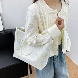 Close-up of a large tote bag with bamboo leaf pattern on white fabric texture