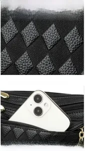 Macro view of diamond textured fabric and a gold zipper pocket holding a smartphone