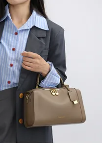 Detailansicht der braunen Lederhandtasche mit goldener Hardware und Litschi-Maserung