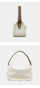 Macro detail of creamy leather texture and brown strap with gold ring hardware
