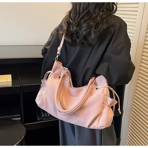 Detalle del bolso tote de ante sintético rosa con cordón y bolsillo lateral en modelo