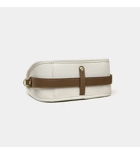Close-up of off-white lychee leather shoulder bag with brown strap and gold metal hardware