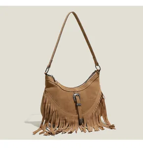 Gros plan détaillé du sac bandoulière rétro en daim avec franges et boucle en métal