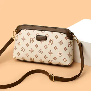 Classic monogram crossbody bag in cream and brown leather with elegant golden hardware