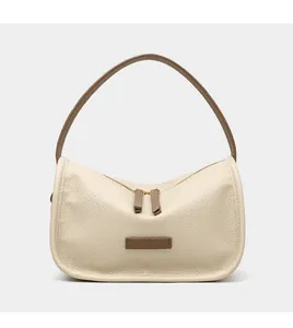 Detailed macro shot of lychee grain leather texture and two-way zipper on cream hobo bag