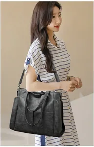 Detailed view of the black soft leather tote bag with fine litchi texture and shoulder strap