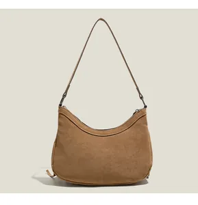 Vue détaillée du sac hobo en daim camel avec une texture mate raffinée et fermeture éclair