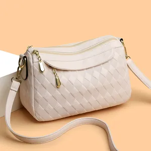 Beige quilted leather crossbody bag with three golden zippers and adjustable strap