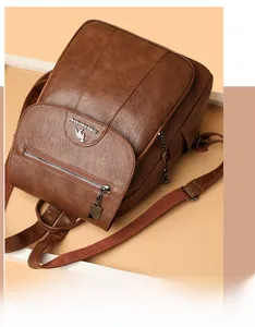 Detail shot of a brown leather backpack featuring a kangaroo logo and textured finish