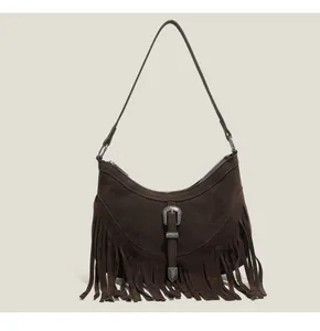 Détail du sac à bandoulière en daim marron foncé avec franges et boucle argentée