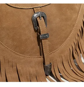 Détail de la texture suédée mate marron avec franges et boucle métallique gravée