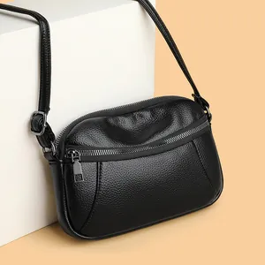 Classic black litchi grain leather crossbody bag with silver zippers and adjustable strap