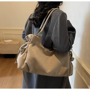 Vista detallada del bolso tote grande de ante caqui con cordones y correa ajustable