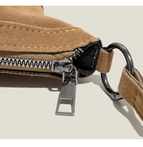 Détails du sac bandoulière en daim marron avec fermeture éclair et coutures de précision