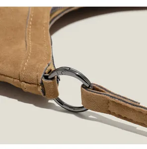 Gros plan détaillé du sac en daim marron avec anneau métallique noir et coutures précises
