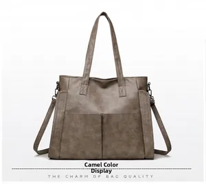 Detail view of large camel tote bag showing lychee grain leather and front slip pockets