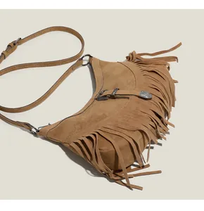 Détail du sac croissant en daim marron avec de longues franges et une boucle vintage chic