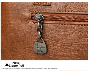 Macro shot of dark gunmetal zipper pull with kangaroo logo on brown pebble leather bag